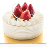 Vanilla cream cake with strawberry on top isolated on white background