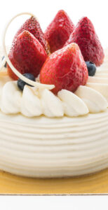 Vanilla cream cake with strawberry on top isolated on white background